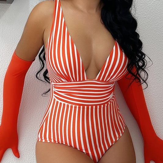 Person wearing a red and white striped swimsuit with red gloves against a light background